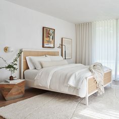 a bedroom with a bed, rug and pictures on the wall