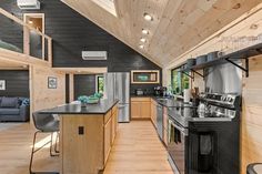 a kitchen with black counter tops and wooden walls, along with an island in the middle