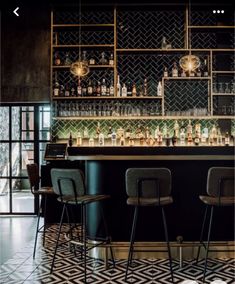 an image of a bar with stools and bottles on the shelves in front of it