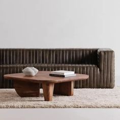 a brown leather couch sitting on top of a rug next to a wooden coffee table