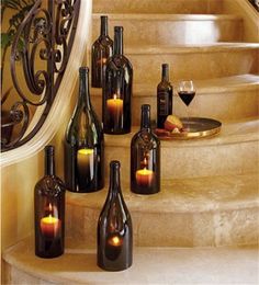 bottles with candles sitting on the steps in front of a stair case that says how to create beautiful wine bottle candle holders