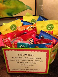 a basket filled with lots of candy sitting on top of a counter next to a sign that says lad am shift