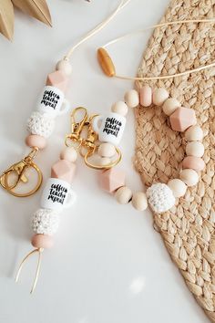 two keychains with white and pink beads, one has a gold charm on it