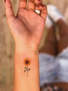 a small sunflower tattoo on the wrist