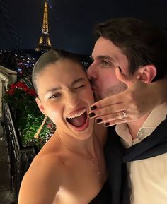 a man and woman posing for a photo in front of the eiffel tower