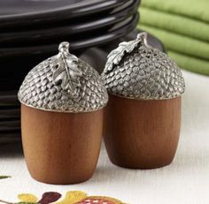 two silver acorns sitting next to each other on a table