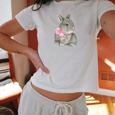 ITEM DESCRIPTION: This darling coquette style bunny tee is a charming addition to your vintage-inspired wardrobe. Featuring a delightful bunny design and accented with a sweet pink ribbon, this tee exudes whimsical charm. Perfect for adding a playful touch to your everyday outfit or for a fun weekend look. Handcrafted with care, this tee is sure to become a favorite piece in your collection. Ideal for those who appreciate a touch of nostalgia and unique style. 🍰 Made from lightweight 100% cotto Coquette Bunny, 90s Fits, Preppy Stuff, Bunny Design, Coquette Style, Soft Girl Aesthetic, 90s Baby, Y2k Baby Tee, Bunny Designs