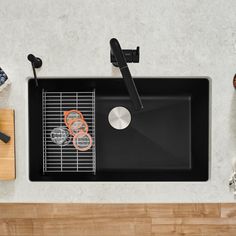 a black sink sitting on top of a counter next to cutting boards and utensils