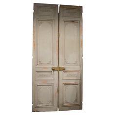 an old pair of white doors with gold handles