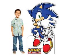 a young boy standing next to a cardboard cutout of sonic the hedgehog