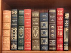 a row of books sitting on top of a wooden book shelf next to each other