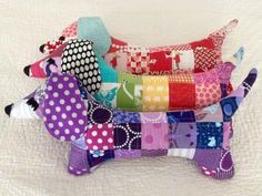 a dog made out of patchwork material on top of a white bed sheet with polka dots