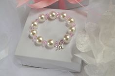 "Flower Girl Bracelets personalized with her monogram initial make a pretty gift for any little girl in your bridal party. Child size FAUX pearl bracelets have alternating Sparkly Pink Crystal beads between some of the faux pearl and a little dainty monogram charm. Add a beautiful gift box with or without a Beautiful Flower Girl Thank You Card Or Flower Girl Proposal Card for the perfect packaging. It is handmade with high-quality materials that will last. All of our bracelets can be made for in Personalized Pink Pearl Bracelet For Birthday, Pink Hypoallergenic Bracelets For Wedding, Pink Adjustable Bracelets For Bridesmaids, Elegant White Name Bracelet For Birthday, Personalized Round Bracelets, Elegant White Bracelets, Hypoallergenic White Bracelet For Bridesmaids, Hypoallergenic White Bracelets As Bridesmaid Gifts, Personalized Pink Charm Bracelet For Wedding