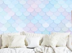 a white couch sitting under a blue and pink wallpaper covered in circles on it's side