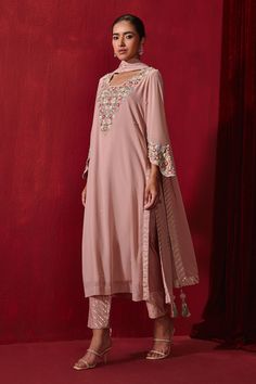 Rose pink straight long kurta with intricate neckline embroidery. Comes with a gota embellished pant and dupatta.
Components: 3
Pattern: Embroidered
Type Of Work: Floral Patterns
Neckline: Round
Sleeve Type: Straight Three Quarter
Fabric: Georgette and Rayon
Color: Pink
Other Details: 
Cutwork neckline and sleeve border
Striped hem dupatta and pant
Occasion: Wedding - Aza Fashions Neckline Embroidery, Long Kurta, Kurta Set For Women, Straight Kurta, Fashion App, Kurta Set, Cut Work, Floral Patterns, Set For Women