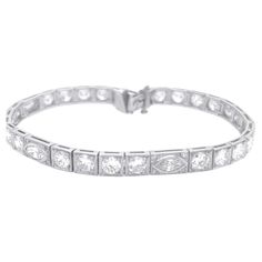 Step into the glamour of the Art Deco era with this exquisite Period Art Deco Diamond Bracelet, adorned with a dazzling display of 8.00 carats of G color, VS clarity marquise and round cut diamonds elegantly set in platinum. The geometric patterns and intricate detailing of this bracelet exude the essence of Art Deco design, making it a true statement piece for those who appreciate the elegance of vintage luxury. Each diamond, with its brilliant G color and VS Clarity, radiates brilliance and sophistication, capturing the spirit of a bygone era. Crafted with precision and artistry, this bracelet is a testament to the timeless beauty and glamour of Art Deco style. Elevate your ensemble with this stunning Period Art Deco Diamond Bracelet, a showcase of refined taste and opulent allure that t Period Art, Bracelet Tennis, Estilo Art Deco, Art Deco Diamond, Art Deco Era, Art Deco Design, Tennis Bracelet, Round Cut Diamond, Geometric Patterns