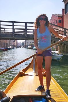 a woman standing on top of a boat in the water