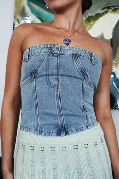 a woman wearing a denim top and skirt