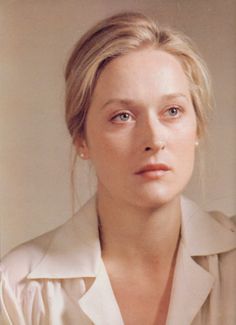 a black and white photo of a woman with blonde hair wearing a collared shirt