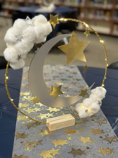 a table topped with a gold and white star and moon decoration on top of it