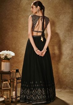 Step into the spotlight with our Black And Gold Embroidered Lehenga Set. This exquisite ensemble showcases a black and gold viscose georgette lehenga, adorned with intricate thread, dori, and sequin work. Its flattering silhouette is enhanced by pockets and cancan for added flair. The accompanying sleeveless blouse features matching scallop pattern embroidery, while a net dupatta with buttis and a handcrafted cutdana & sequin border adds a touch of elegance. Perfect for sangeet or cocktail events, this lehenga set is sure to make you the centre of attention. Composition : Lehenga, Blouse- Viscose Georgette, Dupatta - Soft Net Care: Dry Clean Only and Vacuum Storage This product can be customized for sleeves, length of blouse and neckline Delivery : 2 weeks as the product is hand crafted. C Flair Lehenga, Scallop Pattern, Georgette Lehenga, Georgette Dupatta, Vacuum Storage, Embroidered Lehenga, Indian Wedding Wear, Lehenga Blouse, Cocktail Event