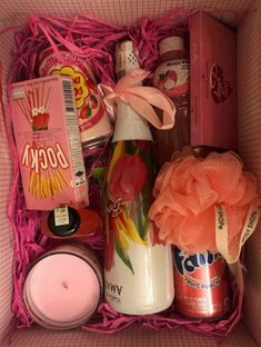 an open pink box containing various items such as candles, soaps and other things