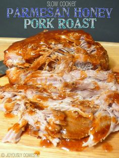 a wooden cutting board topped with meat covered in sauce