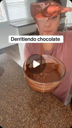 a woman holding a bowl filled with chocolate in front of her face and the words, derritendo chocolate