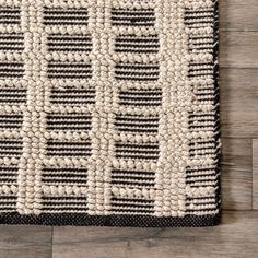 a black and white rug on top of a wooden floor