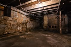 an empty room with exposed pipes and stone walls