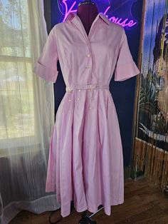 Smart pink Basila vintage dress with belt, likely from the 60's.  Belted with a 3-button closure.  Buttons galore on this posh dress; you will catch eyes for sure! Measurements taken while garment is laying flat: Sleeve (seam to end) - 11" Chest - 17" Waist - 14.5" Back of gown (nape to hem) - 43" Vintage sizes are different than modern sizing, so please review the measurements listed, double them, and measure your body to ensure a decent fit. Please note, items in my shop are vintage and pre-owned.  Some garments will have imperfections, and I do my best to note those in my listing and pictures.  If you have questions, please email me on the item and I will do my best to address them. Some items may be creased in shipping.  Please email me if you aren't sure how to address any wrinkles th Retro Belted Dress For Formal Occasions, Retro Belted Formal Dress, Vintage Belted Dresses For Work, Retro Belted Dresses For Daywear, Vintage Belted Formal Dress, Vintage Belted Workwear Dresses, Vintage Formal Belted Dress, Pink Retro Midi Dress, Vintage Belted A-line Dress