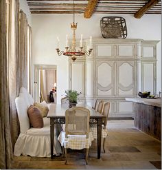 a dining room table with chairs and a chandelier hanging from the rafters