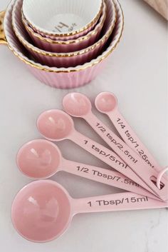 six pink measuring spoons are sitting next to each other