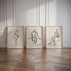 three black and white drawings are on the wall next to each other in an empty room