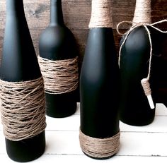 three black bottles with twine tied to them