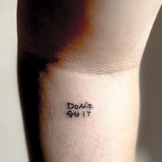 the word don't quit written in black ink on someones left calf sleeve