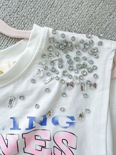 Graphic T-Shirt Cropped Loose Fit Rhinestone Detail On Shoulders Rolling Stones Paired With "Icy Girl" Shorts 95% Cotton 5% Spandex Stretch Crew Neck Top With Rhinestones, Casual Sleeveless Tops With Rhinestones, White Embellished Cotton Tops, Cotton Rhinestone Short Sleeve Top, Rhinestone Cotton Tops With Short Sleeves, Cotton Short Sleeve Top With Rhinestones, Cotton Tops With Rhinestones And Short Sleeves, Casual Pink Embellished Tops, White Rhinestone Crew Neck Top