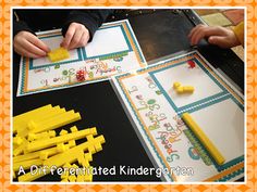 two children are playing with legos on paper and some yellow construction blocks in front of them