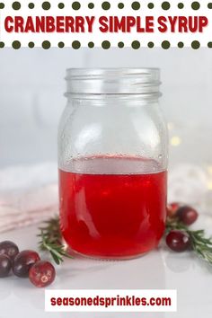 cranberry simple syrup in a jar with berries around it