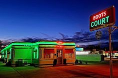 a green and red building sitting next to a neon sign