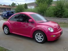 a pink car parked in front of a house