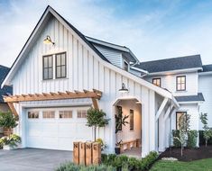 a large white house with two garages on the front and one story above it