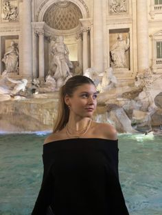 a woman standing in front of a fountain