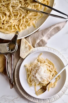 a plate of pasta with parmesan cheese next to a bowl of breadcrumbs