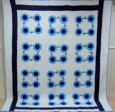 a blue and white quilt with flowers on it