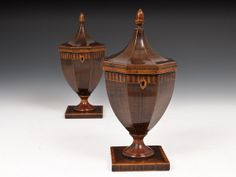 two wooden vases sitting on top of each other in front of a white background