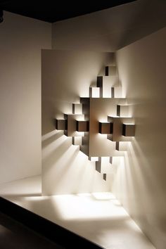 the light shines on an abstract wall sculpture