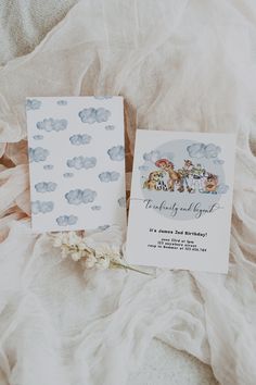 two wedding cards on top of a bed