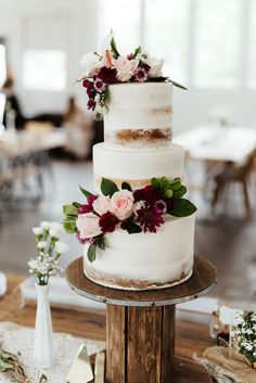 a three tiered white cake with flowers on top