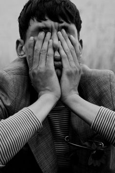 a man covering his eyes with both hands